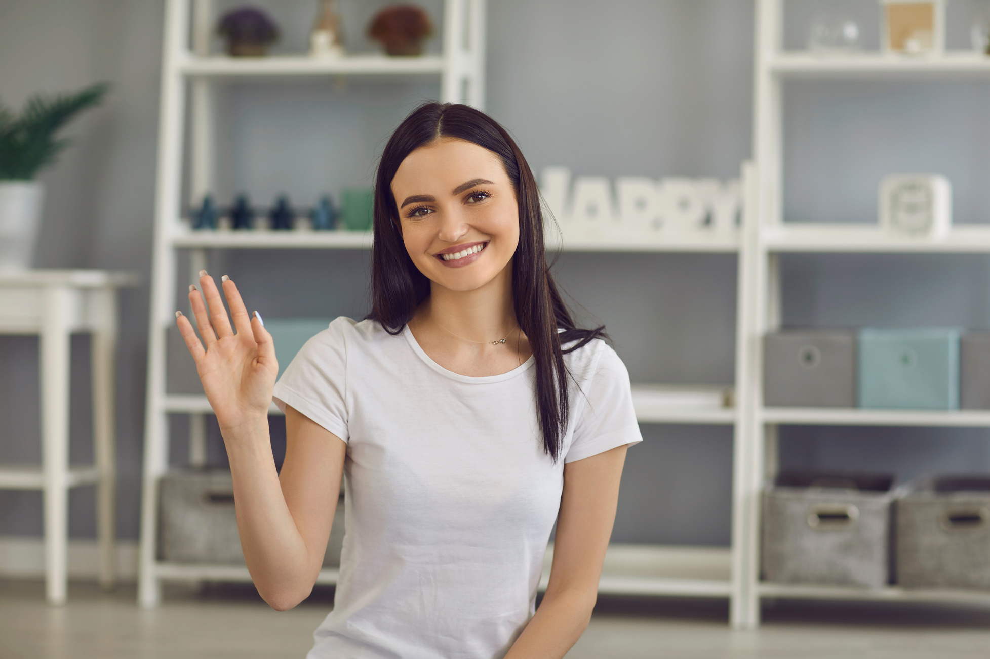 Smiling Girl Blogger Greets and Waves Her Hand Starting Video Recording on Her Blog.